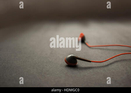 earphones on dark textured background. The earphones for using digital music or smart phone. selective focus of earphones. Stock Photo