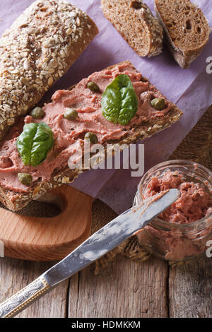 Sandwich with pate and basil close-up on chopping board. vertical Stock Photo
