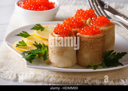 Pancake rolls with red caviar on a plate and lemon. horizontal Stock Photo