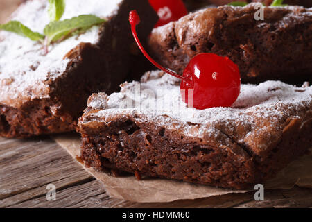 Delicious chocolate brownie cake with cherry closeup on paper. horizontal Stock Photo