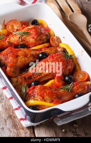 Chicken legs baked in tomato sauce with olives and rosemary close up. vertical Stock Photo