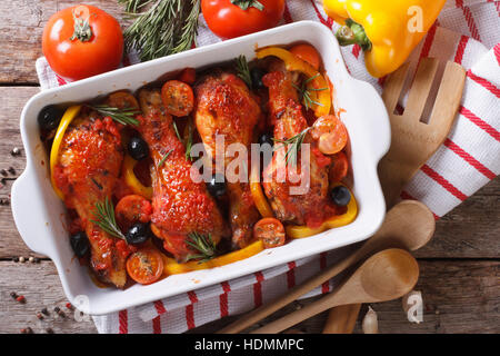 Chicken legs baked in tomato sauce with olives close-up. horizontal view from above Stock Photo