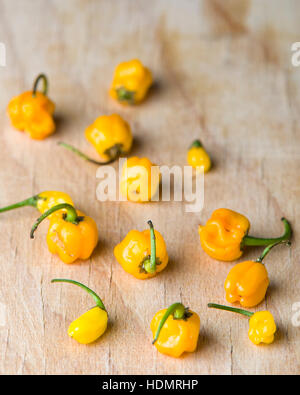 Small yellow homegrown organic chili peppers on a wooden surface background  Model Release: No.  Property Release: No. Stock Photo