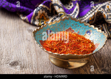 saffron in a metal bowl on the old wooden background Stock Photo