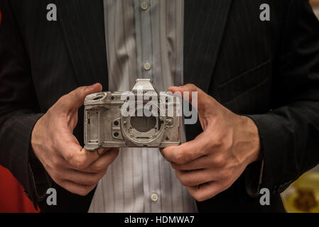 Moscow, Russia - 17 NOVEMBER, 2016: Businessman taking aluminum metal body photo camera OLIMPUS with vintage camera. Close up image photo. metal part Stock Photo