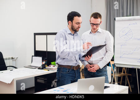 two caucasian corporate executives in casual wear having a business discussion in office. Stock Photo