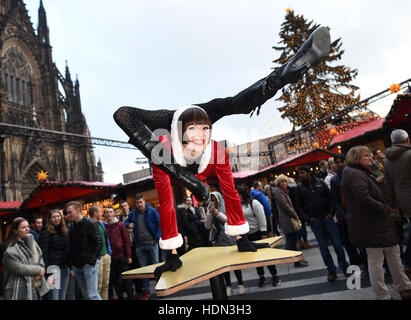 Cologne, Germany. 12th Dec, 2016. Contortionist Alina Ruppel shows off her skills on a table at the Christmas market in Cologne, Germany, 12 December 2016. Ruppel is due to compete in the final of RTL talent show Das Supertalent on 17 December. Photo: Henning Kaiser/dpa/Alamy Live News Stock Photo