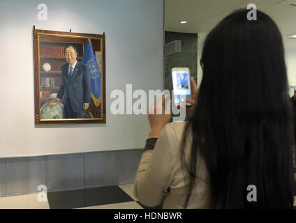 New York, US. 14th Dec, 2016. A visitor photographs the new portrait of the retiring UN General Secretary Ban Ki Moon with her smartphone in the lobby of the United Nation's headquarters in New York, US, 14 December 2016. Photo: Christina Horsten/dpa/Alamy Live News Stock Photo