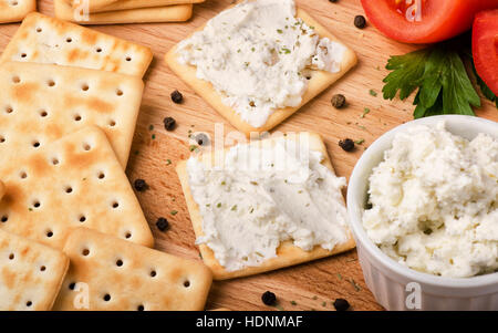 Crackers with cream cheese on a wooden background Stock Photo
