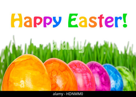 Row of 6 colorful Easter Eggs in front of green grass, text Happy Easter, in vivid rainbow colors Stock Photo