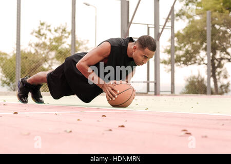 Picture of young basketball player make sport exercises with basketball outdoors Stock Photo