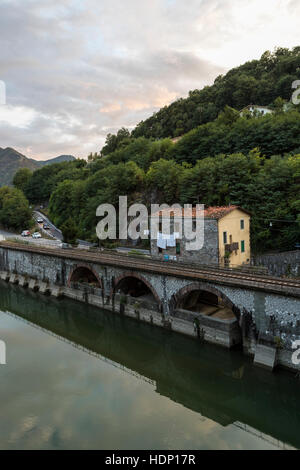 Railway side house and washing at Ponte della Maddalena or Devils Bridge, Borgo a Mozzano, Italy Stock Photo