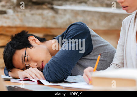 Handsome asian young man in glasses sleeping on the lesson Stock Photo