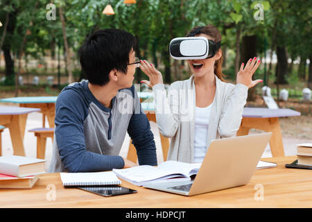 Happy young couple using virtual reality glasses and having fun at the table Stock Photo