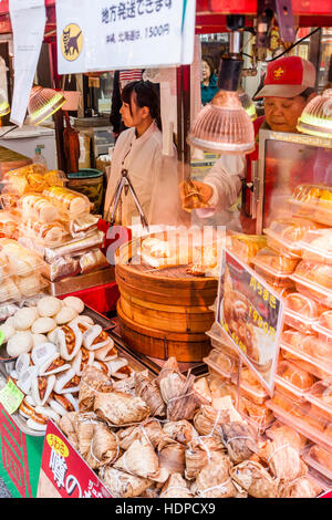 Japan, Kobe, Nankinmachi, Chinatown. Chinese food stall counter, Pork Belly buns being steamed in wooden bowl. Other foods packed on counter. Stock Photo