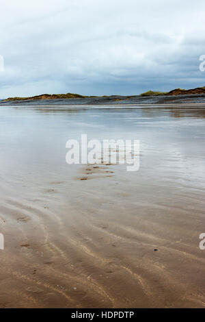 Footprints in the sand on a desolate and windswept sandy beach, Westward Ho!, Devon, England, UK Stock Photo