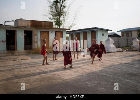 Young novice Buddhist monks playing football at the Shwe Yan Pyay Monastery in Nyaungshwe, Myanmar. Stock Photo