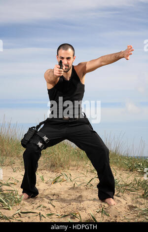 athletic man holding a gun in his hand on the ready Stock Photo - Alamy