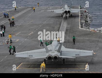 Two Boeing F/A-18E and F/A-18F Super Hornet multi-role fighter combat jet aircraft prepare to launch from the flight deck of the USN Nimitz-class aircraft carrier USS Nimitz November 26, 2016 in the Pacific Ocean. Stock Photo