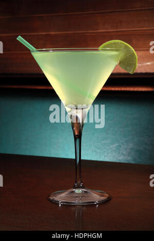 appletini cocktail with lime wheel, vodka, pineapple juice, liqueur in classic martini cocktail glass Stock Photo