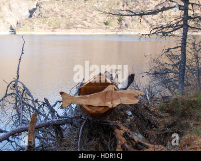 Val Piora, Switzerland: Shark carved out of wood resting on a tree stump Stock Photo