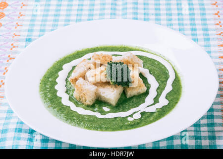 homemade green broccoli cream soup in white plate Stock Photo