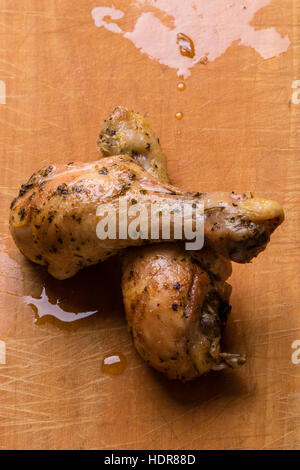 grilled chicken drumsticks on rustic wooden cutting board Stock Photo