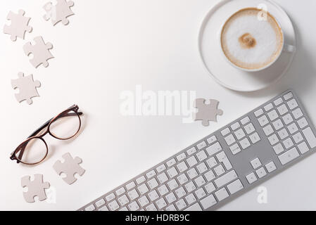 Jigsaw puzzle pieces scattered around the table Stock Photo