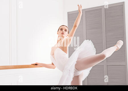 Young ballerina keeping her arm and leg in the air Stock Photo