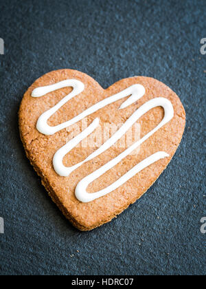 Heart-shaped Christmas gingerbread cookie on a dark background. Stock Photo