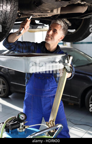 Replacing the motor oil. Mechanic mentions oil. Changing the oil in the car services. Car mechanic lists the engine oil in the c Stock Photo