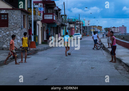 Kids play football barefoot in the street, Baracoa, Cuba Stock Photo