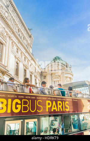 tourists aboard a sightseeing bus of big bus fleet in front of opera garnier, west facade