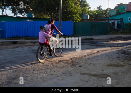 Woman taking child to school on the back of a bicycle, Vinales, Cuba Stock Photo
