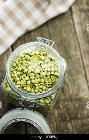 Green split peas in jar on old wooden table. Stock Photo