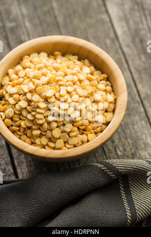 Yellow split peas in bowl on wooden table. Stock Photo