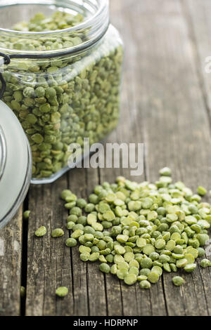 Green split peas in jar on old wooden table. Stock Photo