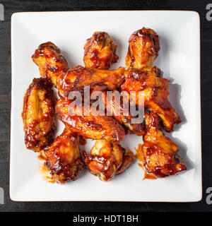 Baked chicken wings served on a white plate close up Stock Photo