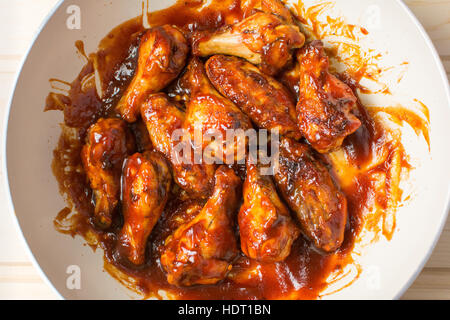 Chicken wings baking on a ceramic pan in sauce Stock Photo