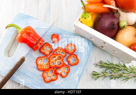 Cutting red pepper on a wooden tray. Cooking abstract Stock Photo