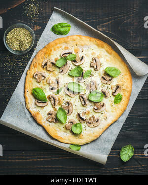 Homemade round mushroom pizza with basil and spices in glass Stock Photo