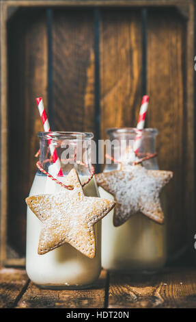 Bottles with milk for Santa and Christmas festive gingerbread cookies Stock Photo