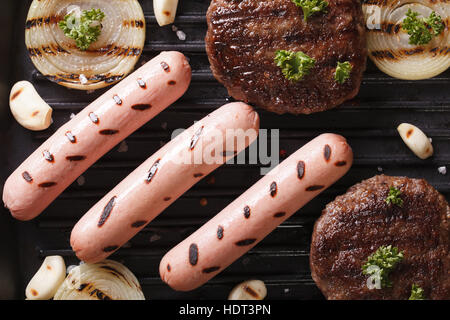 burgers and sausages with grilled vegetables closeup. horizontal view from above Stock Photo