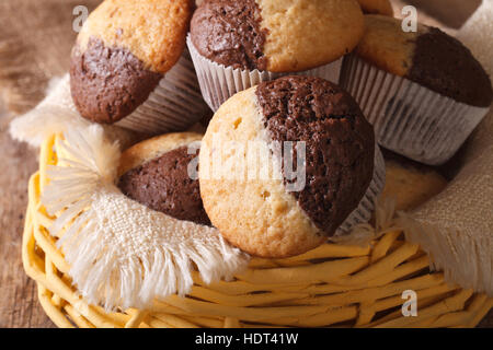 two-tone muffins orange and chocolate close-up in a basket. horizontal Stock Photo