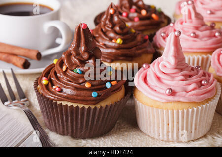 Delicious cupcakes with butter cream and coffee on the table. Horizontal close-up Stock Photo