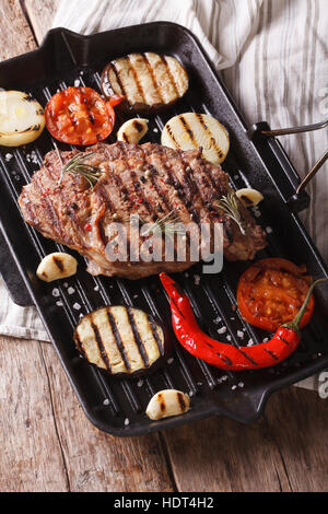 beef steak grilled with onions, eggplant and chilli in a frying pan grill closeup. vertical Stock Photo
