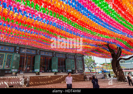 People under paper lanterns at the Jogyesa Temple in Seoul, South Korea. Lanterns are set for the Buddha's birthday. Stock Photo