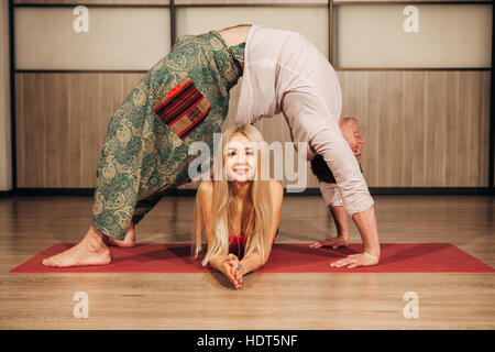Young man and woman doing yoga in pair Stock Photo