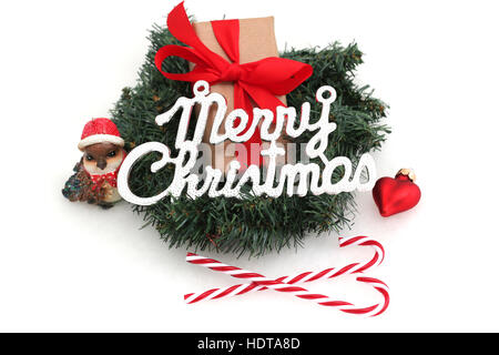 A Christmas present in a wreath with Christmas decorations and the word Merry Christmas Stock Photo