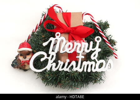 A Christmas present in a wreath with Christmas decorations and the word Merry Christmas Stock Photo